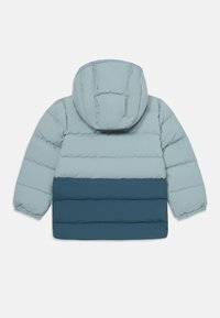 Polstret jakke i lyseblå og mørk teal, med horisontale kviltede seksjoner og hette. Glatt tekstur, elastiske mansjetter og slank design.