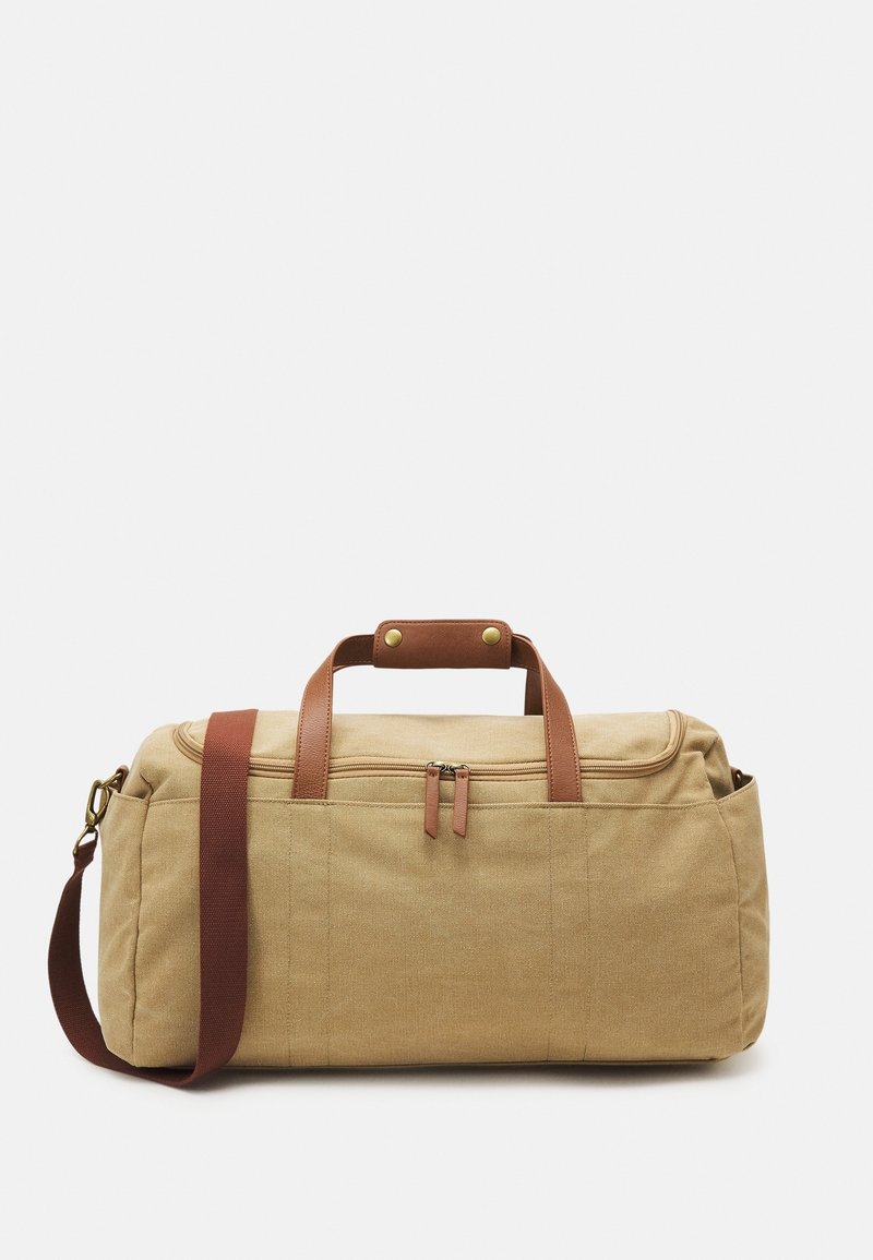 Khaki duffel-laukku ruskeilla nahkakahvoilla ja -koristeilla. Varustettu vetoketjulla ja säädettävällä olkahihnalla. Rakenteellinen kangas.