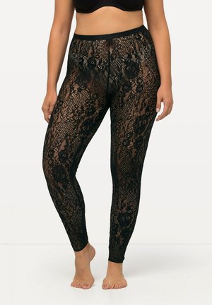 Zwarte kanten legging met bloemmotieven en een hoge tailleband. De stof is doorschijnend met een rekbare textuur, ontworpen om nauwsluitend op het lichaam te zitten.