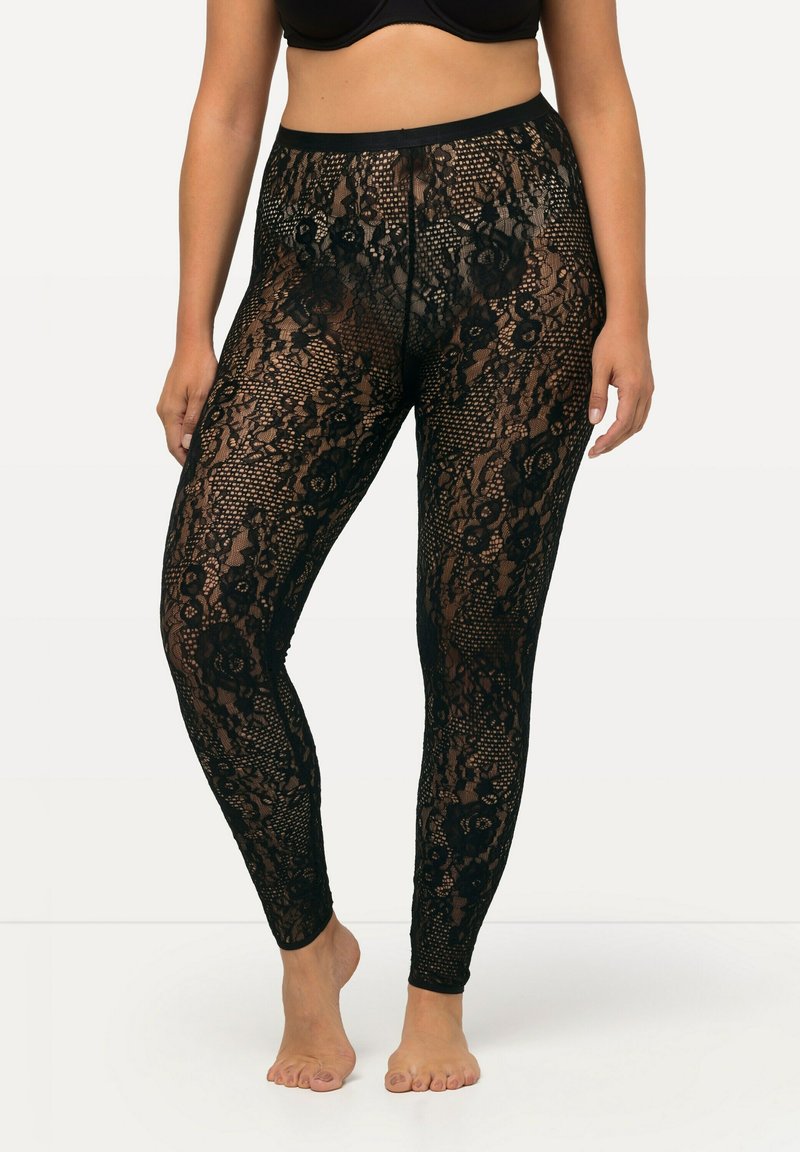 Schwarze Spitzenleggings mit floralen Mustern und einem hohen Bund. Der Stoff ist durchsichtig und hat eine dehnbare Textur, die dafür ausgelegt ist, eng am Körper zu sitzen.