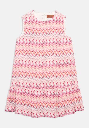 Różowa sukienka bez rękawów z wzorem zygzakowym w odcieniach różu, pomarańczu i bieli, z falbaną na dole i okrągłym dekoltem.