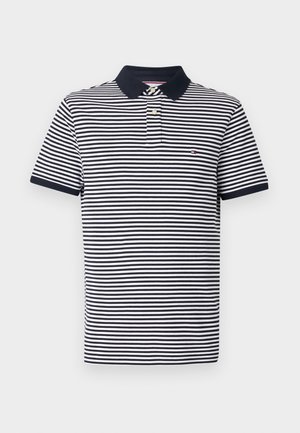 Tumed ja valged triibulised polo särk klassikalise kraega, lühikeste varrukatega ja väikese broderi logoga rinnal. Pehme puuvillane materjal.