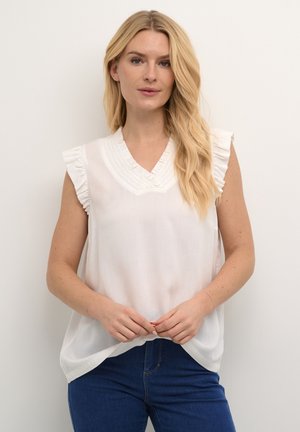Haut sans manches blanc avec un col en V et des épaules volantées. Présente des détails texturés autour de l'encolure et une coupe ample et fluide.