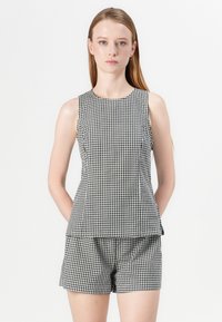 Schwarzes und weißes Gingham-Ärmelloses Oberteil mit rundem Halsausschnitt und lässiger Passform, kombiniert mit passenden Shorts. Strukturierter Baumwollstoff.