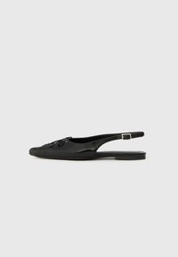 Black leather slingback shoe with a rounded toe, decorative bow detail, flat heel, and adjustable buckle strap. Smooth texture, minimalistic design.