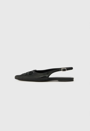 Black leather slingback shoe with a rounded toe, decorative bow detail, flat heel, and adjustable buckle strap. Smooth texture, minimalistic design.