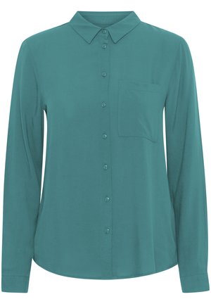 Chemise à manches longues teal en tissu lisse, avec un col classique, une fermeture à boutons sur le devant et une poche poitrine unique.