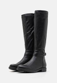 Knee-high mustast nahast saapad sileda tekstuuriga, külgsaidist vööna ja madala plokknõrga detailiga.
