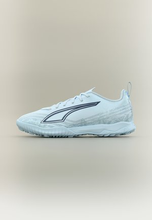 Zapatilla deportiva azul claro con suela texturizada, logo lateral, cierre de cordones y lengüeta en un fondo neutro.