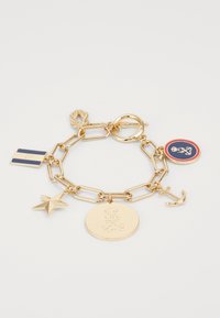Bracelet en chaîne dorée comportant de grands maillons, une étoile, un médaillon rond avec un design en relief, un pendentif en forme d'ancre et un pendentif en couleur représentant un drapeau.