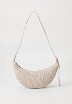 Sac à épaule beige en forme de croissant avec texture en tissu côtelé et bandoulière réglable, présenté sur un fond uni.