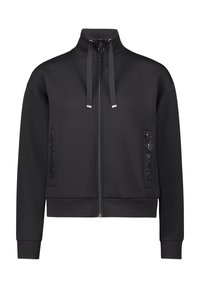 Czarna bluza na zamek z wysokim kołnierzem, dwoma przednimi kieszeniami ozdobionymi czarnymi cekinami oraz regulowanym sznurkiem przy szyi. Trwały materiał.