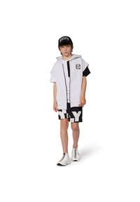 Un sweat à capuche gris superposé sur un T-shirt noir, associé à un short noir avec un graphique blanc "SLY", des baskets blanches et une casquette noire.