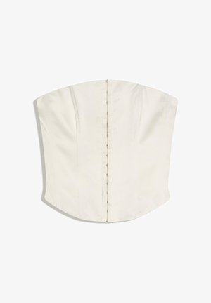 Haut blanc style corset sans bretelles avec fermetures à agrafes sur le devant et détails subtils de coutures verticales.