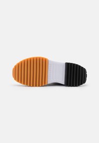 Podeszwa buta z żłobionym wzorem gripu, z pomarańczowym przodem, białym środkiem z napisem "CONVERSE" oraz czarnymi tylnymi sekcjami na białym tle.