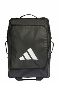 Crni ruksak izrađen od izdržljive tkanine s ručkom na vrhu, bočnim trakama i velikim bijelim Adidas logotipom sprijeda; kvadratnog oblika s elegantnim dizajnom.