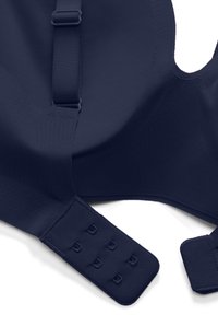 Sezione di reggiseno blu navy con spallina regolabile e chiusura a ganci e occhielli con tre file di ganci su tessuto liscio.