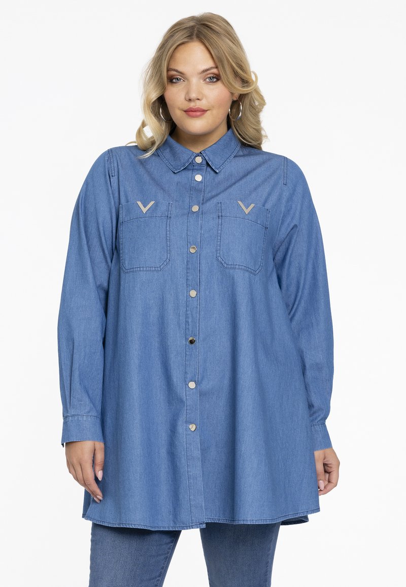 Jeanshemd, hellblau, langärmlig, mit Knopfleiste vorne, zwei Brusttaschen mit V-förmigen Akzenten, lockerer Schnitt, weicher Stoff.