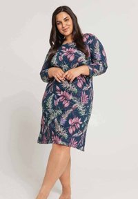 Kwiecista sukienka do kolan w kolorze granatowym z różowymi i zielonymi botanicznymi wzorami. Długie rękawy, luźny krój, miękka tkanina, okrągły dekolt.