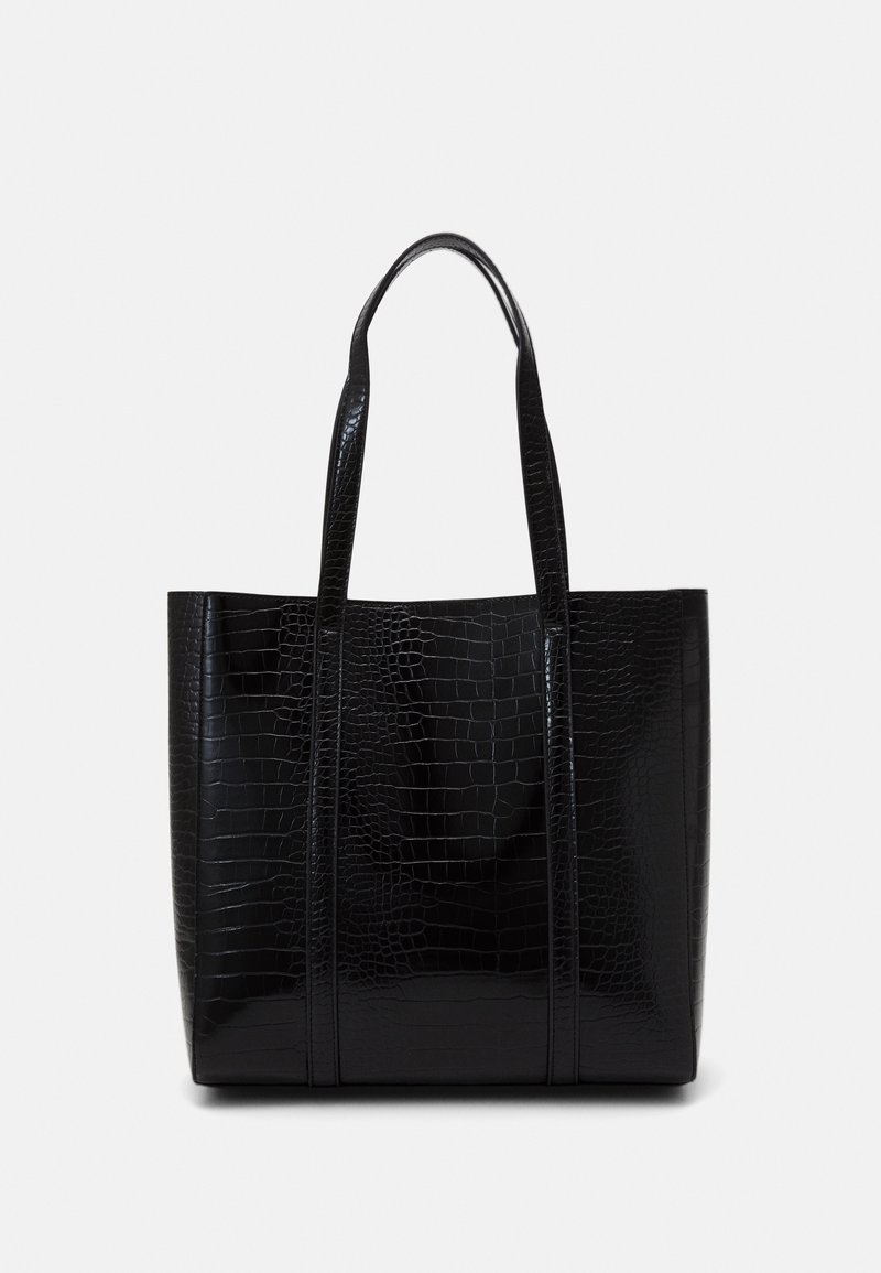 Sac cabas noir à texture crocodile, deux longues anses et forme rectangulaire sur un fond clair uni.