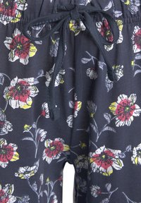 Marineblauwe pyjamashorts met een witte, rode en gele bloemenpatroon. Zacht materiaal, elastische tailleband met een trekkoord voor verstelbaarheid.