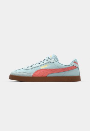 Light blue leather sneaker with pink accents, round toe, textured surface, flat brown rubber sole, lace-up design, and logo detail on side.