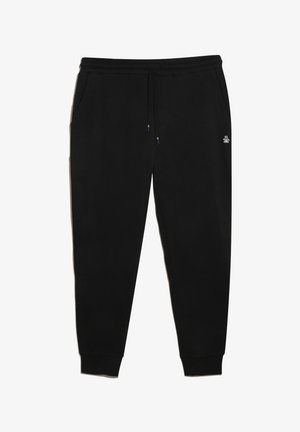 Pantalons de jogging noirs en tissu doux, avec une taille élastique et un cordon de serrage, des poches latérales et des poignets côtelés. Détail de logo discret.