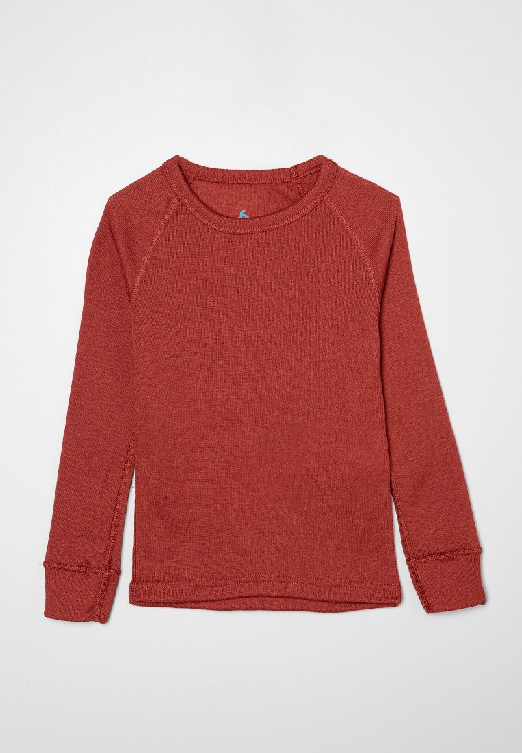 Chemise rouge à manches longues en tissu texturé avec un col rond et des manches raglan. Présente des ourlets cousus et une étiquette bleue au niveau du col.