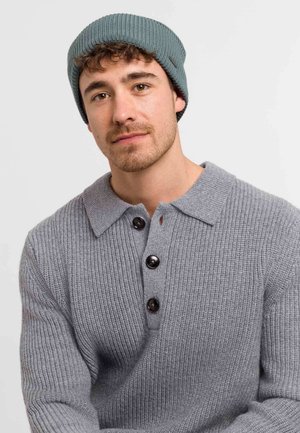 Gray ribbed knit sweater with a collar and three black buttons. Worn with a teal knitted beanie. Texture appears soft and warm.