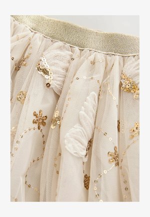 Kreemikas tuulekanga seelik kuldse elastse vöökohaga, kaunistatud kuldsete litrite ja lillemustriliste tikanditega, mis loovad tekstuurse ja kihilise välimuse.