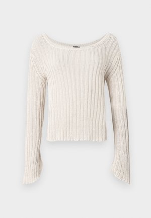 Maglione cropped di colore crema con scollatura ampia e maniche lunghe a campana. Il tessuto in maglia a coste presenta una trama morbida.