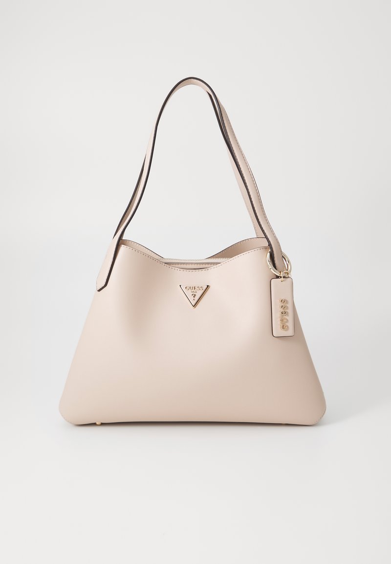 Borsa beige con texture liscia, logo triangolare in oro e tracolla regolabile. Include un piccolo tag con il nome del marchio attaccato.