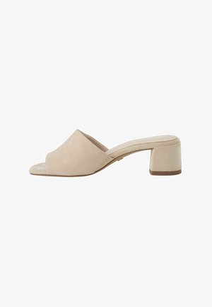 Mule beige in suede con punta aperta, tacco basso a blocco e design slip-on, mostrata di lato su sfondo bianco.