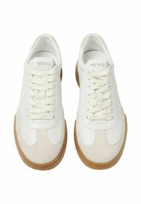 Sneaker bianche in pelle con accenti in suede color cammello, lacci piatti e suola in gomma. Presentano dettagli cuciti e un design minimalista.