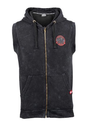 Zwarte mouwloze hoodie met een rits aan de voorkant, twee zijzakken, gouden hardware en een rode cirkelvormige logo op de borst. Textuurstof.