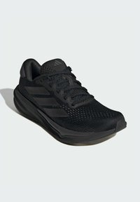 Scarpa da ginnastica nera realizzata in mesh traspirante con sovrapposizioni in materiale sintetico, caratterizzata da una suola intermedia testurizzata e tre strisce contornate sui lati.