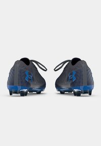 Scarpe da calcio nere e blu con una parte superiore testurizzata, forma aerodinamica e logo prominente sul lato. Presentano un design con lacci e suole con tacchetti.