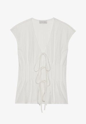 White short-sleeved top with a deep V-neck and front tie detail. The fabric has a smooth texture with vertical pleating accents.