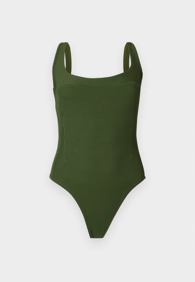 Πράσινο ολόσωμο μαγιό με ριγέ υφή, φαρδιές τιράντες και τετράγωνη λαιμόκοψη, εμφανίζεται πάνω σε απλό φωτεινό φόντο.