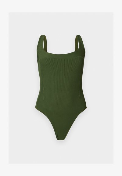 Πράσινο ολόσωμο μαγιό με ριγέ υφή, φαρδιές τιράντες και τετράγωνη λαιμόκοψη, εμφανίζεται πάνω σε απλό φωτεινό φόντο.