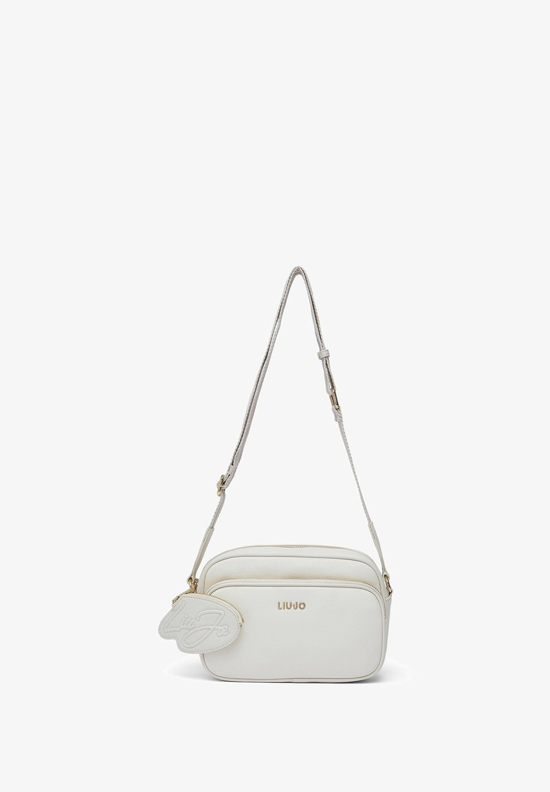 Sac bandoulière en similicuir blanc avec deux compartiments zippés, garnitures dorées, et un porte-clés amovible avec un logo manuscrit.