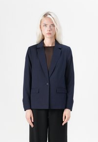Námořnický blazer s jedním knoflíkem, klopami a dvěma předními kapsami. Střižený střih s hladkým povrchem.