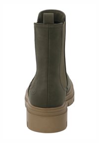 Botines hasta el tobillo de color verde oliva con acabado suave de ante, punta redondeada y suela de goma beige. Cuenta con una lengüeta en el talón para facilitar su uso.