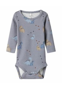 Bodysuit pour bébé à manches longues gris avec boutons pressions, arborant des motifs de dinosaures bleus et beiges ainsi que de petits dessins de empreintes.