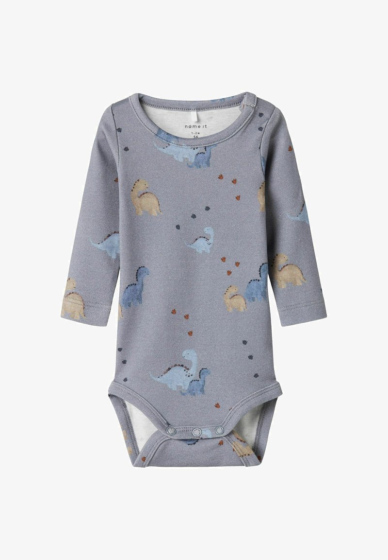 Bodysuit pour bébé à manches longues gris avec boutons pressions, arborant des motifs de dinosaures bleus et beiges ainsi que de petits dessins de empreintes.