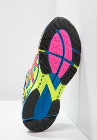 Semelle de chaussure de course avec un design multicolore, comportant des accents jaune vif, rose et bleu, et en caoutchouc noir texturé pour une traction et un soutien.