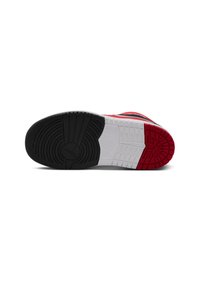 Schwarze, weiße und rote Sneaker-Sohle mit einem auffälligen Profilmuster, glattem Gummi-Material und einem mittig eingeprägten Logo.