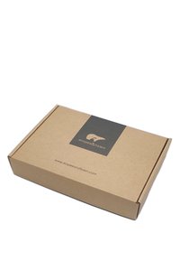 Scatola di cartone marrone con superficie texture, con un'etichetta grigio scuro che presenta un logo e del testo. Design semplice e rettangolare.