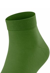 Calzino verde alla caviglia con bordo a costine, texture liscia e design a vestibilità che si adatta alla forma del piede.