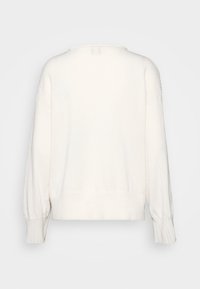 Cremfarbener Pullover mit lockerer Passform, gerippten Bündchen und Saum, einer leichten, weichen Textur und dezenten Schulterdetails.